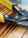 Close-up of a pair of yellow manual iron scissors on a wooden background