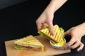 Close up on pair of young girl`s hands removing a healthy wholesome wholemeal bread ham sandwich Royalty Free Stock Photo