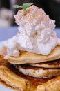 Close up Pancakes with caramel-banana syrup topping with whip cream and mint leaves
