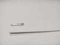 Paper clip holding a blank paper sheet on white background. Royalty Free Stock Photo