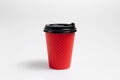 Close-up of paper cup with black plastic lid for coffee takeaway of red color isolated on white studio background Royalty Free Stock Photo