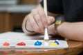 Close-up of paper painter color palette with acrylic paint on a table