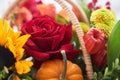 Close-up of a part of a bouquet with a beautiful autumn decoration of pumpkin, red rose and sunflower. The concept of