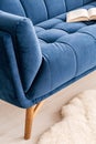 Close-up of a part a couch dressed in luxurious navy blue tapestry in a living room interior. An open book on the sofa. Real photo Royalty Free Stock Photo