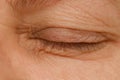 Close up part face mature woman 55 years old, closed human eye, lower, upper eyelid, deep wrinkles around eyes, age-related skin