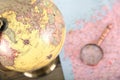 Close-up of a part of the globe and a map and magnifying glass spread out on the bottom table Royalty Free Stock Photo
