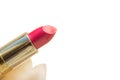 Close-up of a part of a golden tube of lipstick on a white background