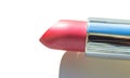 Close-up of a part of a golden tube of lipstick on a white background