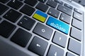 Close-up part of a laptop, black keyboard of a laptop computer, blue, yellow buttons of the Ukrainian flag with the word donate,