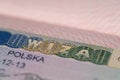 close-up part of page of document, foreign passport for travel with Poland visa, tourist schengen visa stamp with hologram with Royalty Free Stock Photo