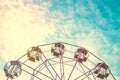Part of pastel ferris wheel on blue sky,