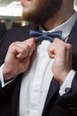 Close-up of part of stylish dark blazer, white shirt, waistcoat and bow tie