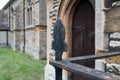 Close-up of part of a wrought-iron gate and fence seen adjacent to an entrance to a historic church. Royalty Free Stock Photo