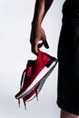 close-up partial view of african american sportsman holding sports shoes Royalty Free Stock Photo