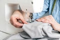 Close-up partial view of seamstress working with sewing machine