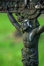 Close up partially destroyed ancient iron statue of the crucifixion of Jesus Christ