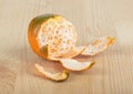 Close-up of a partially peeled tangerine on a wooden background. Royalty Free Stock Photo