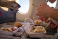 Close-up passenger plane eats tasty hot meal on board on a folding table. in the background is a window in the porthole. Royalty Free Stock Photo