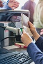 Close up of passenger service agent looking at mature man passport in airport