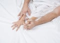 Close up of passionate couple hold hands during making intense love in bedroom, lovers enjoy hot sex on white sheet Royalty Free Stock Photo