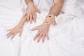 Close up of passionate couple hold hands during making intense love in bedroom, lovers enjoy hot sex on white sheet Royalty Free Stock Photo