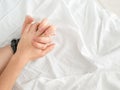 Close up of passionate couple hold hands during making intense love in bedroom, lovers enjoy hot sex on white sheet Royalty Free Stock Photo