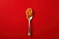 Close up of pasta isolated on red background in spoon or fork Royalty Free Stock Photo