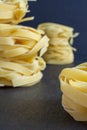 Close-up of pasta with pile of fettuccine defocused back on black background