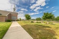 Close up of pathway leading to a church with white steeple under cloudy blue sky Royalty Free Stock Photo