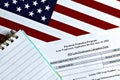 Close-up of paycheck protection program loan forgiveness application form revised topview, on a background of United States flag. Royalty Free Stock Photo
