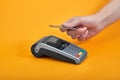 Close-up of payment machine buttons with human hand holding plastic card near by on yellow background Royalty Free Stock Photo