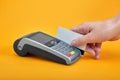 Close-up of payment machine buttons with human hand holding plastic card near by on yellow background Royalty Free Stock Photo