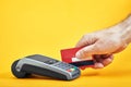 Close-up of payment machine buttons with human hand holding plastic card near by on yellow background Royalty Free Stock Photo