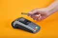 Close-up of payment machine buttons with human hand holding plastic card near by on yellow background Royalty Free Stock Photo