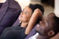 Close up peaceful African American couple relaxing on cozy sofa