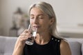 Close up peaceful middle-aged woman drinking natural water Royalty Free Stock Photo