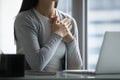 Close up peaceful wishful businesswoman holding hands on chest