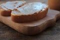 Close-up of Peanut butter sandwiches on wooden background. Slices of bread with peanut paste on a cutting board.