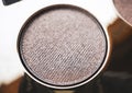 A close-up of pearlescent shimmery gold eyeshadow for creating eye makeup. Beauty concept