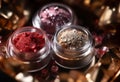 A close-up of pearlescent shimmery red,pink and orange glitter eyeshadows for creating eye makeup