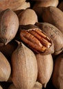 close up of pecan nuts in shell, one nut cracked, background Royalty Free Stock Photo