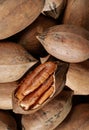 close up of pecan nuts in shell, one nut cracked, background Royalty Free Stock Photo