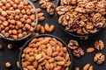 Close-up, peeled walnuts, almonds and hazelnuts in bowls on a black