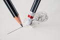 Close up of a pencil eraser removing a crooked line and the close up of a sharpened pencil writing a straight line.