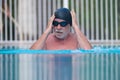 Close up of pensioner man in the pool doing exercise alone swimming - active people and healthy and fit senior - lifestyle of