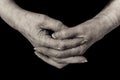 Close up of a pensioner`s hands clasped. Monochrome.