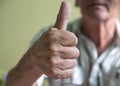 Close-up Pensioner shows thumbs up. A positive elderly man held out his hand and showed a thumbs up. Selective focus