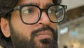 Close up pensive serious male face eyes in glasses looking distance. Bearded Indian Arabian businessman think look to Royalty Free Stock Photo