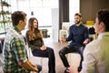 Close-up of people communicating while sitting in circle and gesturing. Royalty Free Stock Photo