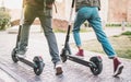 Close up of people couple using electric scooter in city park - Millenial students riding new modern ecological mean of transport